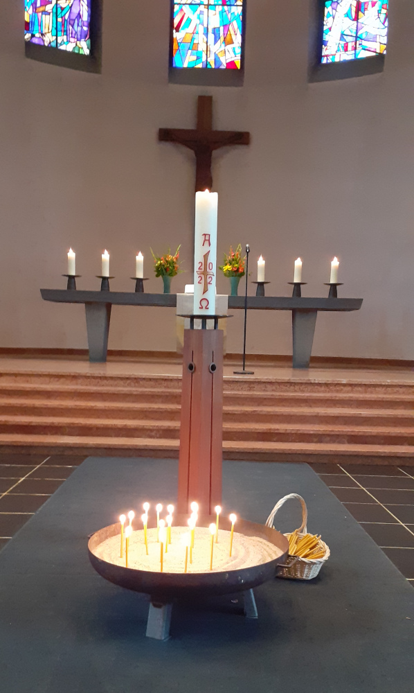 Kerzenschale - gefüllt mit Gebetskerzen durch die Teilnehmenden. Nach dem Kerzengebet mit Musik wurde das Fürbittgebet zweisprachig gesprochen. Aufnahme nach der Friedensandacht am 21. Mai 2022. Bild jh