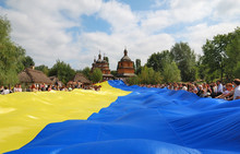 Ukrainische Flagge gehalten von vielen Menschen vor einer Kirche. Bild oleg_mit pixabay