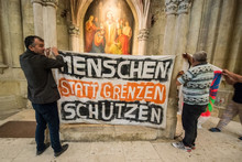 Flüchtlinge demonstrieren 2016 im Dom St. Peter in Regensburg und bitten um Kirchenasyl. (© picture-alliance/dpa)